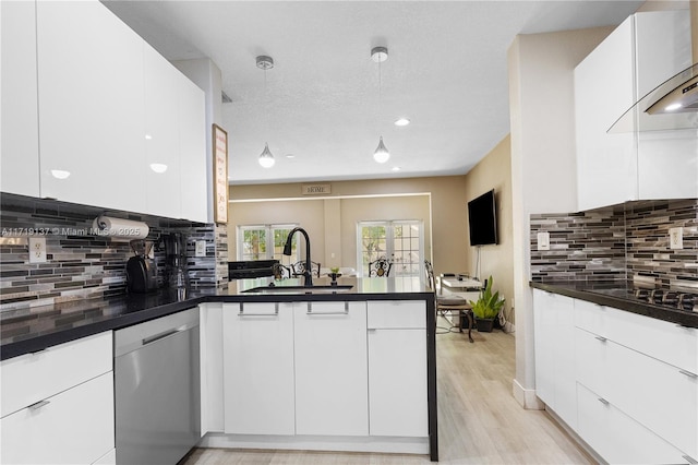 kitchen with dishwasher, sink, tasteful backsplash, kitchen peninsula, and white cabinets