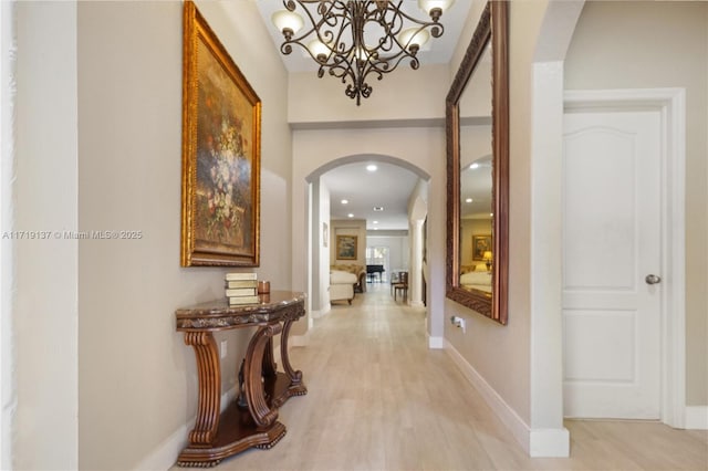 hall with a notable chandelier and light hardwood / wood-style floors