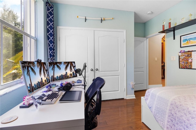 bedroom with dark hardwood / wood-style floors and a closet