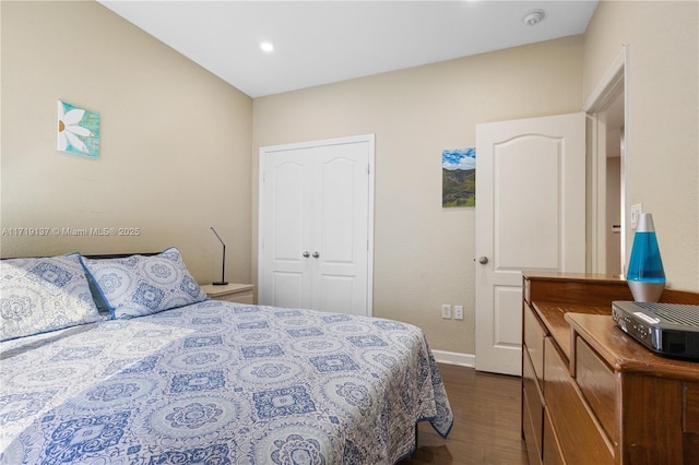 bedroom with dark hardwood / wood-style flooring and a closet