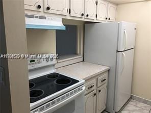 kitchen with white appliances, white cabinets, and range hood