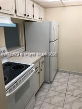 kitchen featuring white cabinets and range