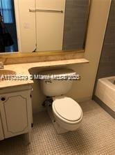 bathroom featuring a washtub, tile patterned flooring, vanity, and toilet