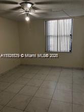 empty room featuring tile patterned flooring and ceiling fan