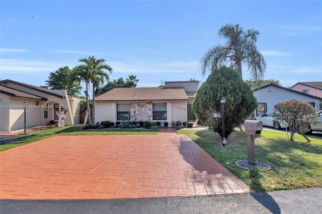 single story home with a front lawn