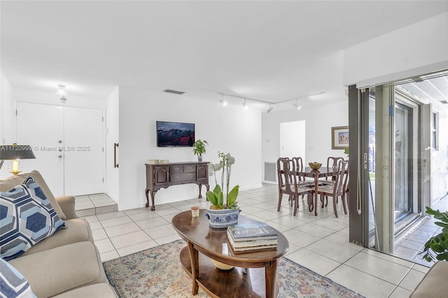 living area with light tile patterned floors, rail lighting, and visible vents