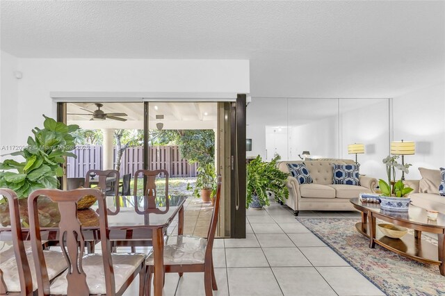 living room with ceiling fan, a textured ceiling, and light tile patterned floors