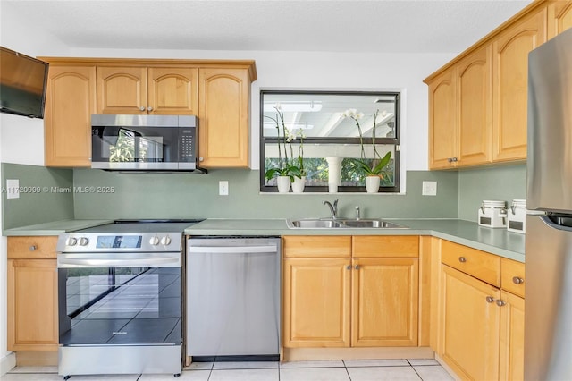 kitchen featuring light tile patterned floors, appliances with stainless steel finishes, light countertops, light brown cabinets, and a sink