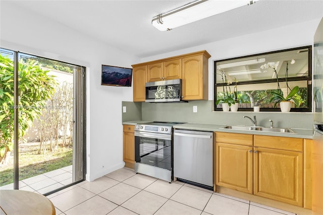 kitchen featuring a sink, light tile patterned floors, stainless steel appliances, and light countertops