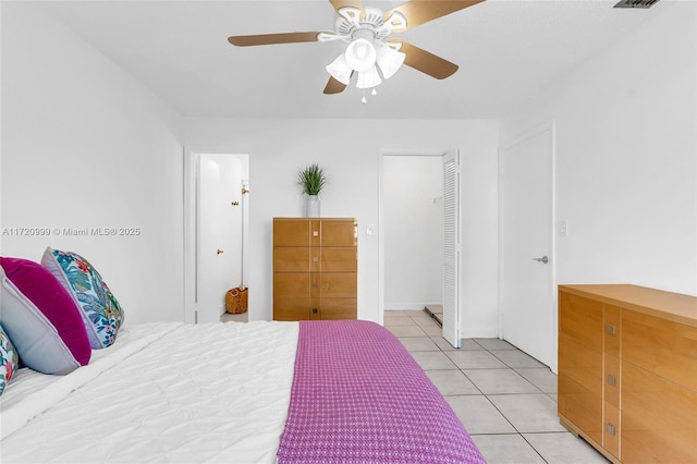 bedroom with light tile patterned floors, a ceiling fan, and a closet