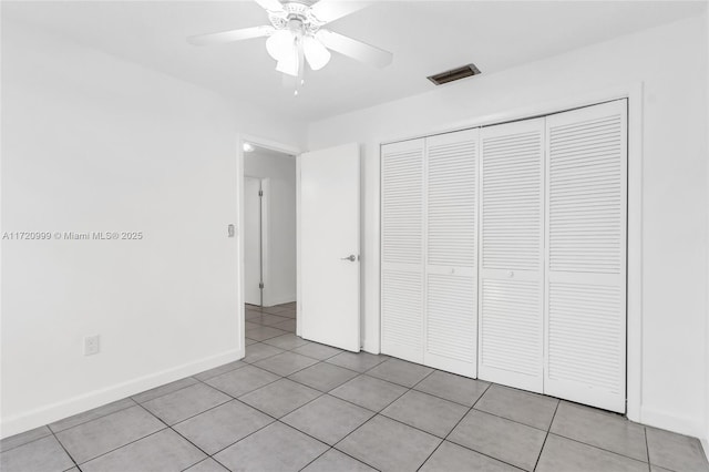 unfurnished bedroom with light tile patterned floors, a closet, visible vents, and baseboards