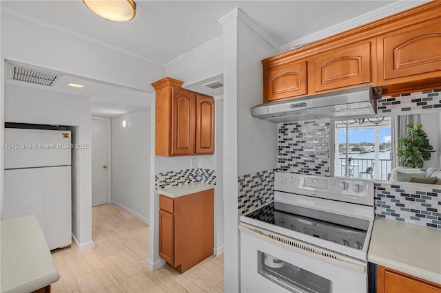 kitchen featuring decorative backsplash, ornamental molding, white refrigerator, and electric range