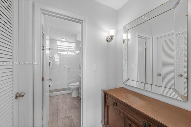 bathroom featuring vanity, toilet, and an enclosed shower