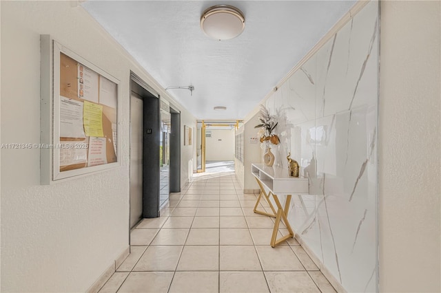 corridor featuring light tile patterned floors and elevator