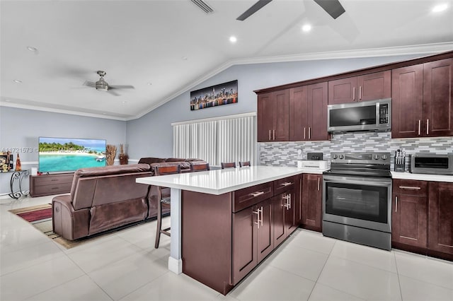 kitchen featuring a breakfast bar, ornamental molding, appliances with stainless steel finishes, and vaulted ceiling