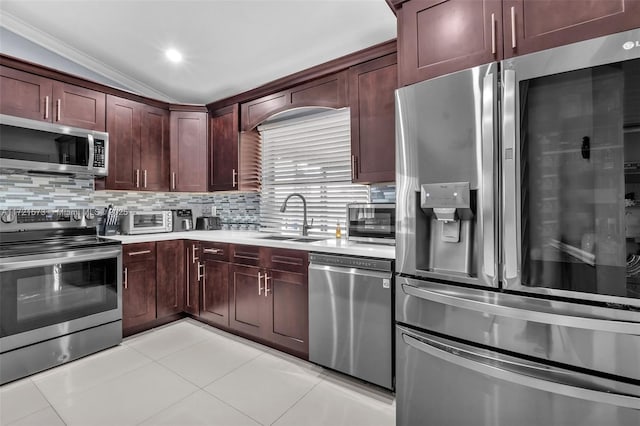 kitchen with lofted ceiling, backsplash, sink, appliances with stainless steel finishes, and light tile patterned flooring