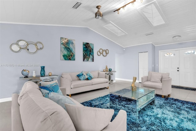 living room featuring tile patterned floors, ceiling fan, ornamental molding, and vaulted ceiling with skylight