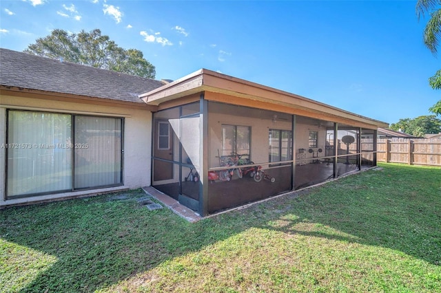 back of house with a lawn and a sunroom