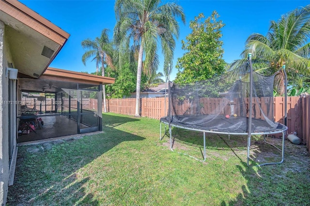 view of yard with a trampoline and ceiling fan