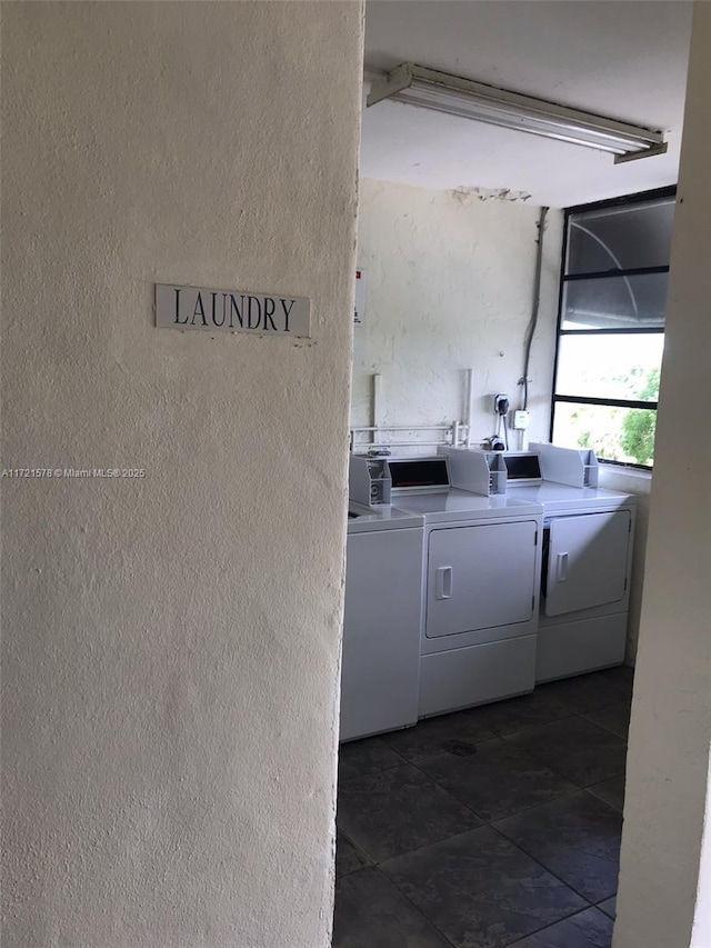 laundry area featuring dark tile patterned floors and separate washer and dryer