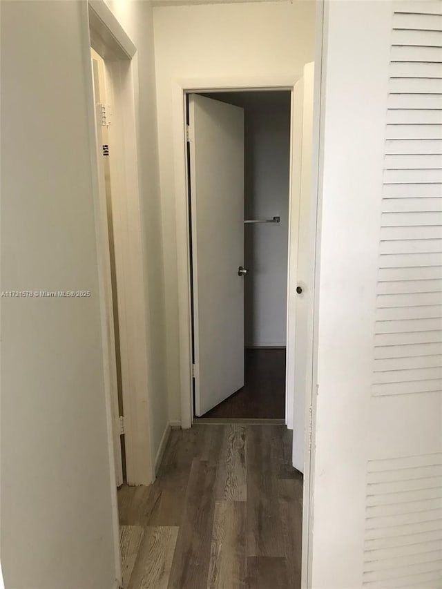 hallway with dark hardwood / wood-style flooring