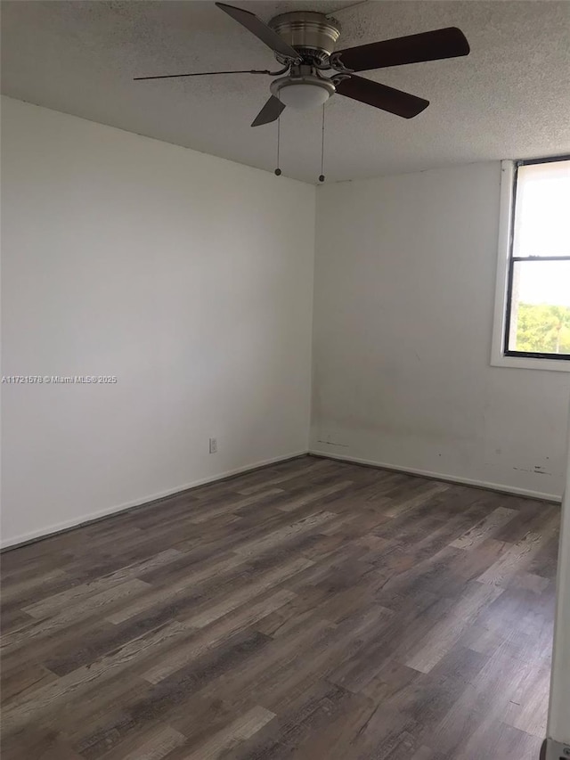 empty room featuring a textured ceiling, dark hardwood / wood-style flooring, and ceiling fan