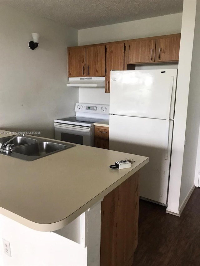 kitchen featuring a textured ceiling, white appliances, sink, and dark wood-type flooring