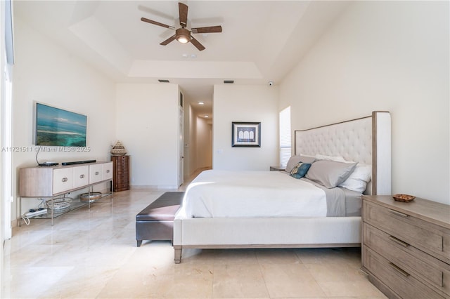 bedroom with ceiling fan and a raised ceiling