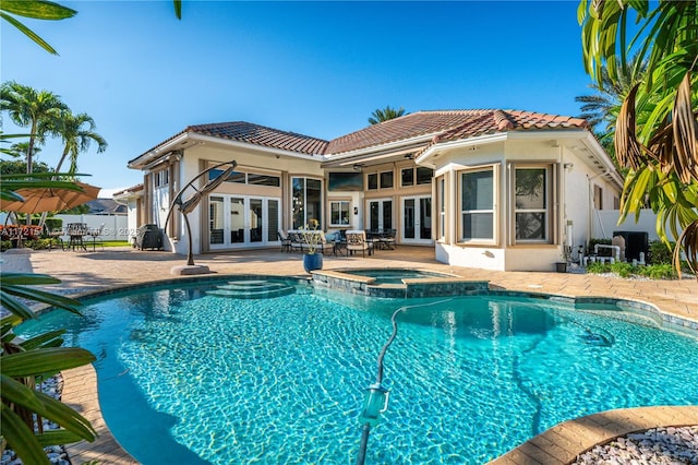 view of swimming pool with a patio area, an in ground hot tub, and french doors