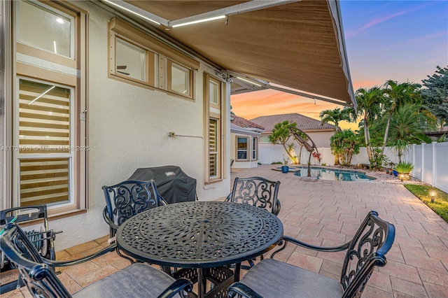 patio terrace at dusk featuring area for grilling