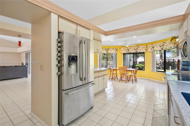 kitchen featuring stainless steel fridge, ceiling fan, light tile patterned floors, cream cabinetry, and lofted ceiling