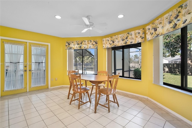 tiled dining area featuring ceiling fan and french doors