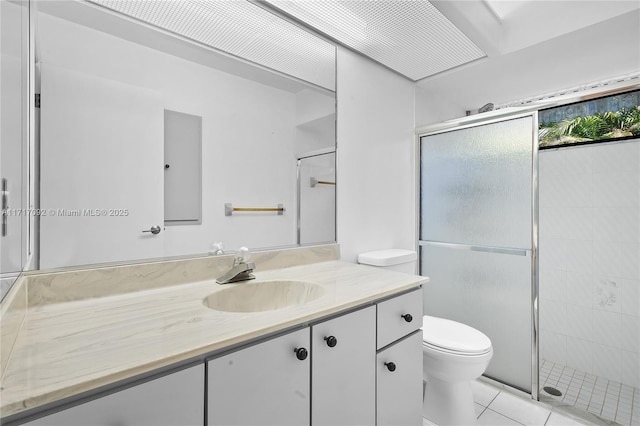 bathroom featuring tile patterned floors, vanity, an enclosed shower, and toilet