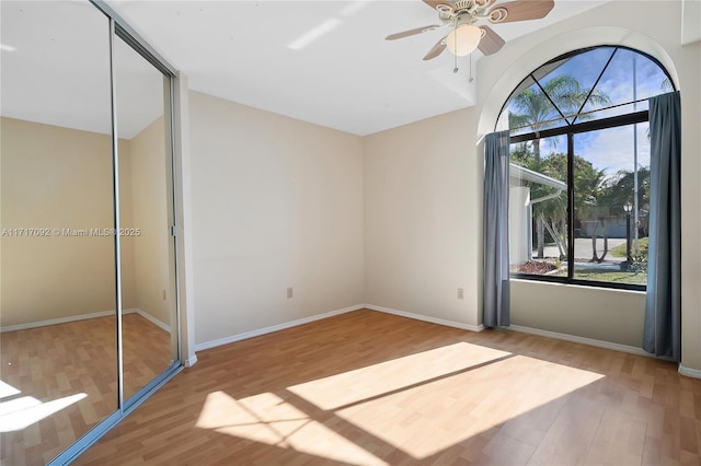 unfurnished bedroom featuring hardwood / wood-style floors, a closet, and ceiling fan