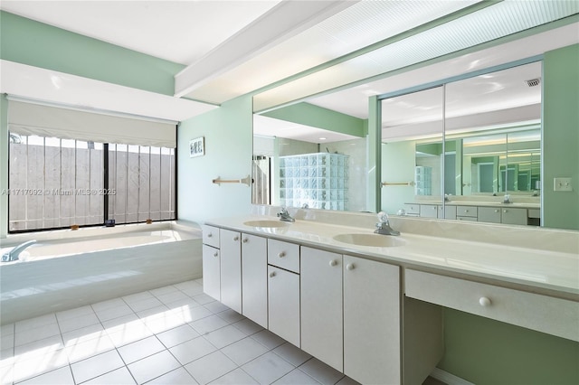 bathroom featuring plus walk in shower, vanity, and tile patterned floors