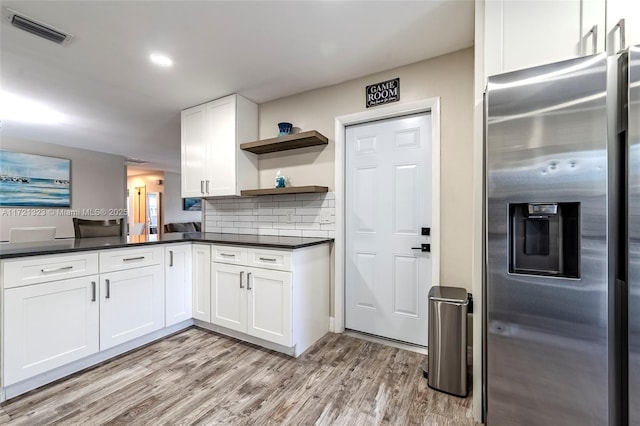 kitchen featuring light hardwood / wood-style flooring, decorative backsplash, white cabinets, and stainless steel refrigerator with ice dispenser