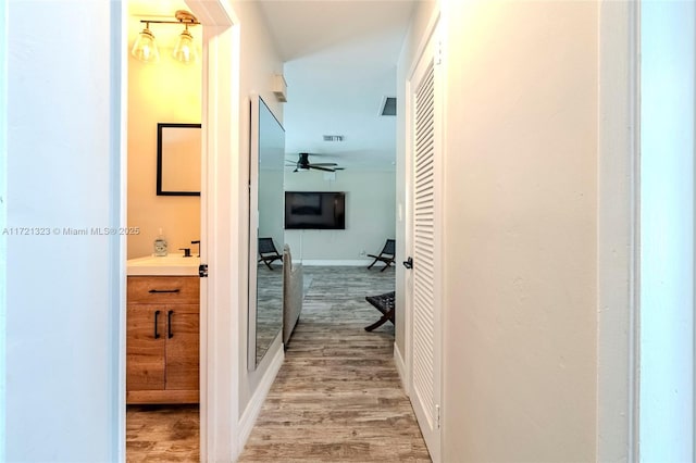 hall with hardwood / wood-style flooring and sink