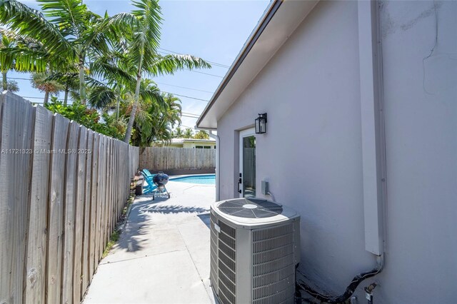 view of patio / terrace with central AC unit and a fenced in pool