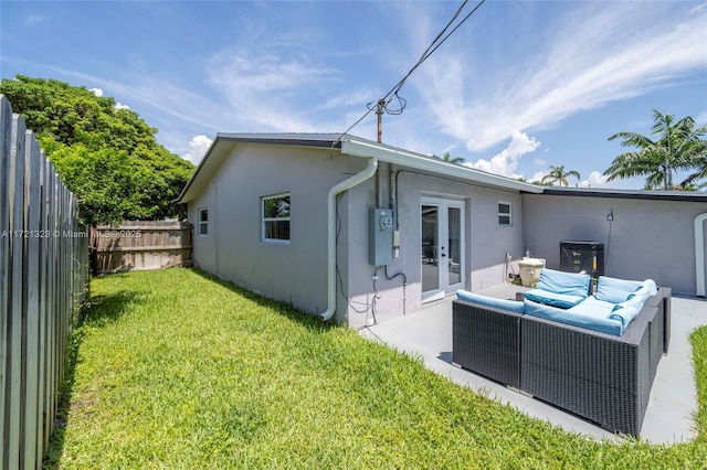 rear view of house featuring outdoor lounge area, a yard, french doors, and a patio area