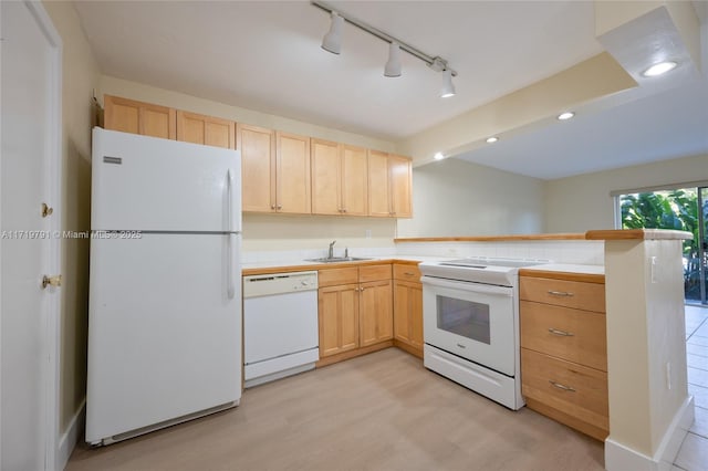 kitchen with white appliances, sink, light brown cabinetry, light hardwood / wood-style floors, and kitchen peninsula