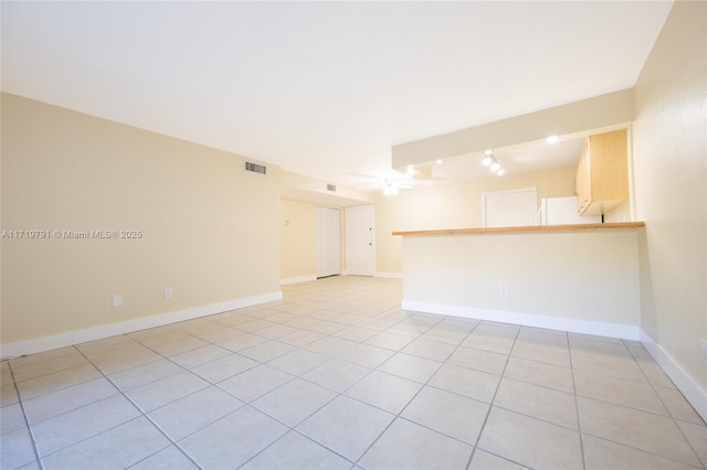 tiled spare room featuring ceiling fan