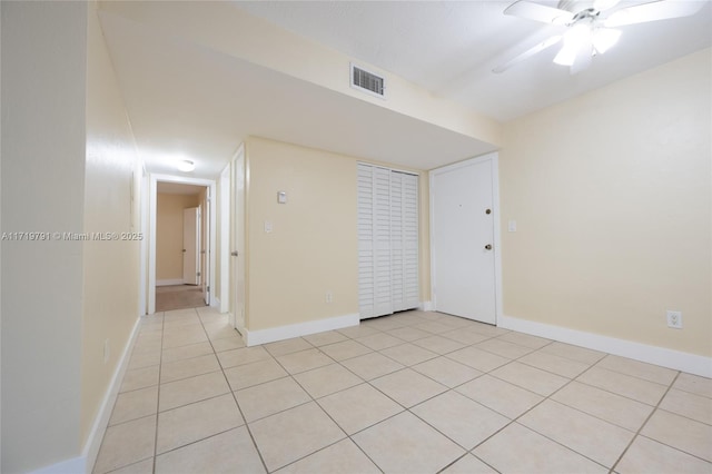 tiled spare room with ceiling fan