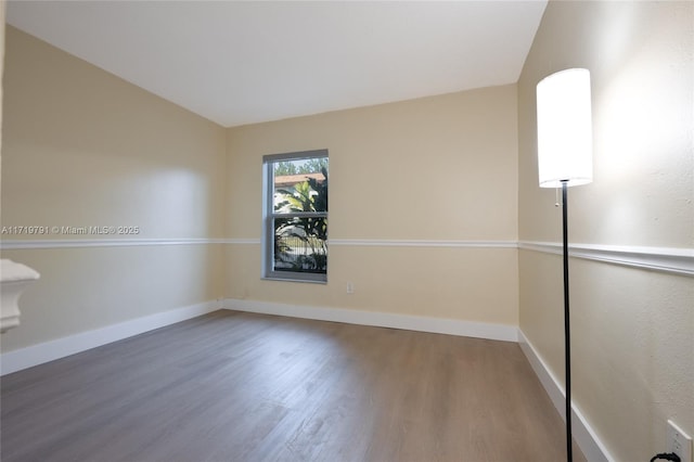 unfurnished room with dark hardwood / wood-style flooring