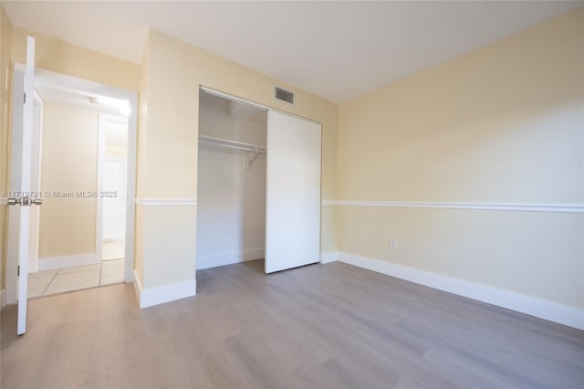 unfurnished bedroom featuring a closet and light wood-type flooring