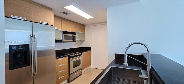 kitchen with light tile patterned flooring, sink, and stainless steel appliances