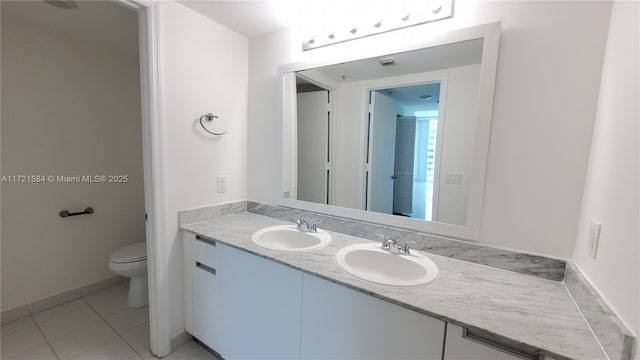 bathroom featuring tile patterned flooring, vanity, and toilet