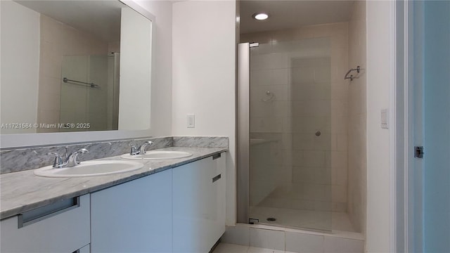 bathroom featuring tile patterned floors, vanity, and a shower with shower door