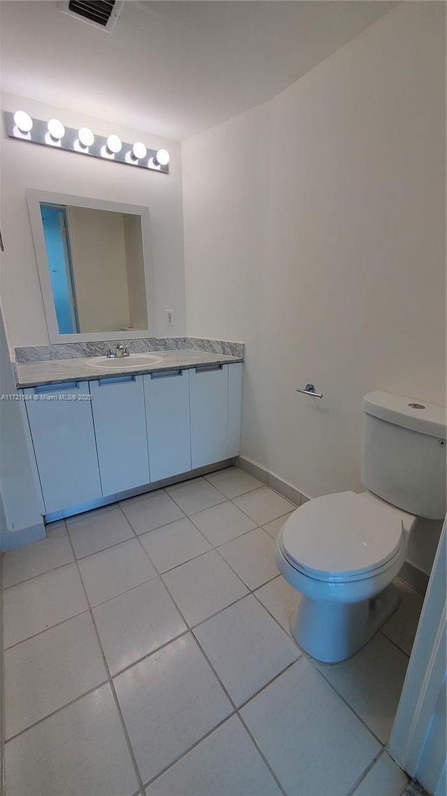 bathroom featuring toilet, vanity, and tile patterned floors