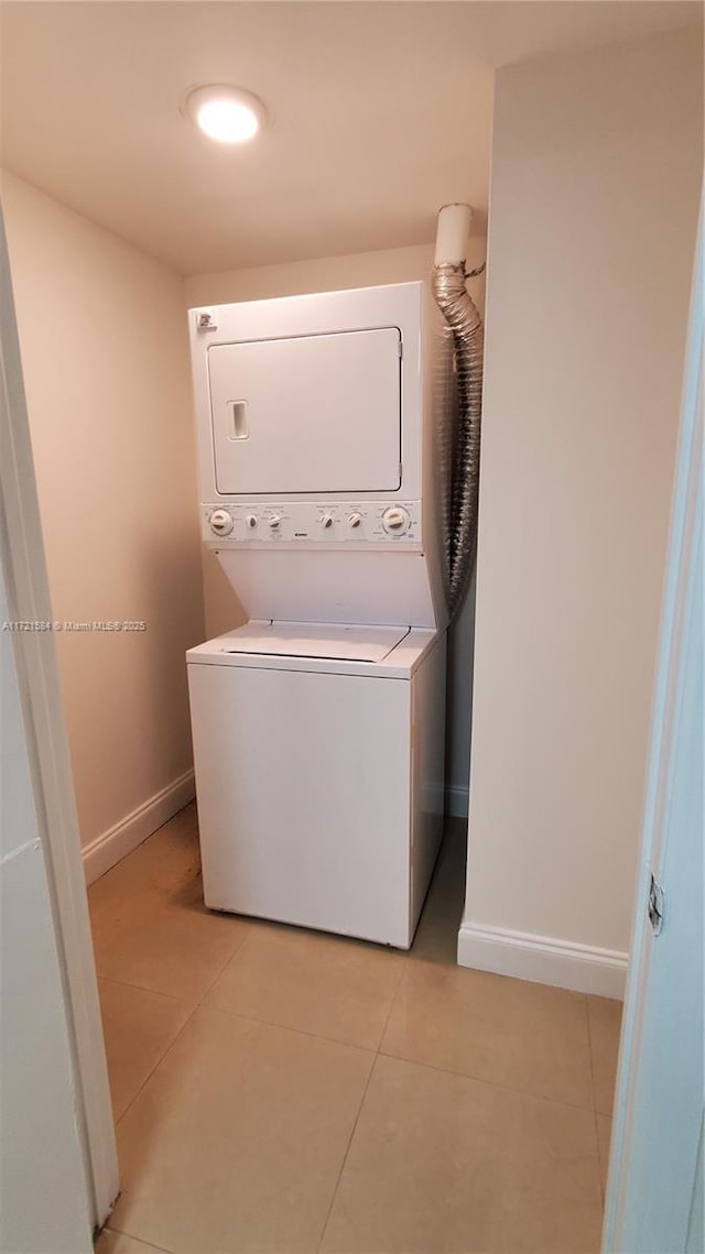 washroom featuring stacked washer / dryer and light tile patterned floors