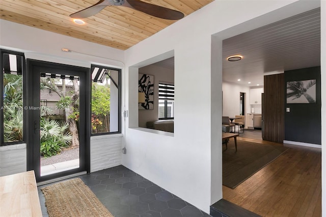 entryway featuring dark tile patterned floors and wooden ceiling